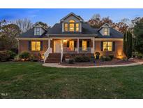 Brick home with landscaped yard, charming porch, and updated lighting at 1991 Webster Grove Dr, Mebane, NC 27302