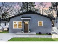 Gray brick house with a brown door, landscaping, and a driveway at 2405 Lane St St, Durham, NC 27707