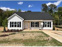 Charming new construction home featuring white siding, a black roof, and a cozy front porch at 286 Longbow Dr, Middlesex, NC 27557