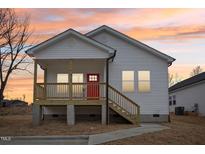 Charming single Gathering home featuring a welcoming front porch with a vibrant red front door at 825 Graham St, Burlington, NC 27217