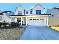 Two-story farmhouse with white siding, brown accents, and a two-car garage at 1709 Chestnut Falls Rd, Wendell, NC 27591