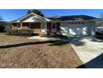 Brick ranch home with attached garage and well-maintained lawn at 307 Westfield Dr, Dunn, NC 28334