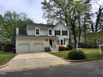 Charming two-story home features a two-car garage, white siding, black shutters, and a landscaped yard at 4300 Hickory Ridge Dr, Raleigh, NC 27609