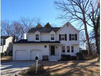 Charming white two-story home with a two-car garage and well-maintained front yard on a sunny day at 4300 Hickory Ridge Dr, Raleigh, NC 27609
