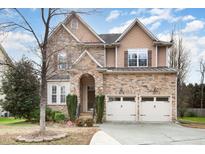 Two-story house with stone accents and a three-car garage at 5 Teahouse Ct, Durham, NC 27707