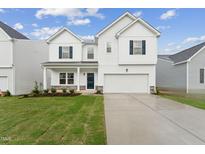 Two-story white house with dark gray accents and a grassy lawn at 513 Marthas View Way, Wake Forest, NC 27587