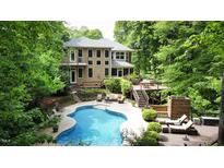 Relaxing pool area with a kidney-shaped pool, outdoor seating, and mature landscaping at 5240 Indigo Moon Way, Raleigh, NC 27613