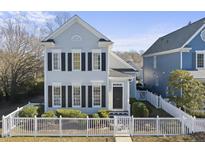 Gray two-story house with white picket fence and dark shutters at 103 Carpenter Town Ln, Cary, NC 27519