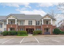 Inviting condo exterior featuring brick accents, covered patios, and well-maintained landscaping in a desirable neighborhood at 105 Fountain Ridge Pl, Holly Springs, NC 27540