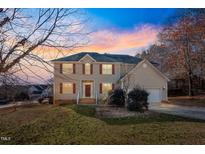 Two-story house with tan siding, red shutters, and a two-car garage at 1216 Magnolia Hill Rd, Garner, NC 27529