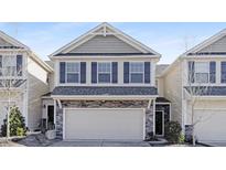 Two-story townhome with stone accents and neutral siding at 207 Explorer Dr # 261, Morrisville, NC 27560