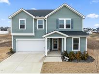 Two-story house, gray siding, attached garage, and a welcoming porch at 233 John Stark Dr, Fuquay Varina, NC 27526