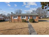 Brick ranch house with a yard, walkway, and satellite dish at 630 Holly St, Burlington, NC 27217