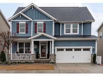 Two-story house with blue siding, red shutters, and a stone facade at 109 Durban Meadow Dr, Holly Springs, NC 27540