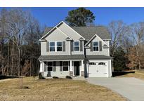 Two-story house with gray siding, two-car garage, and a landscaped yard at 171 Wynd Crest Way, Benson, NC 27504