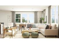 Bright living room featuring a sectional sofa, coffee table, and large windows at 1888 Sweet Gardenia Way, Apex, NC 27502