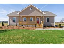 Charming single-story home with a welcoming front porch and a bright red front door at 1820 Johnson Rd, Burlington, NC 27217