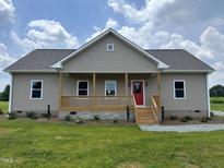 Charming single-Gathering home featuring a welcoming front porch and a red front door at 1820 Johnson Rd, Burlington, NC 27217