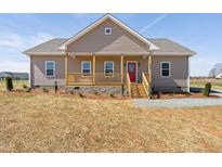 Charming single-story home with a covered front porch and a bright red front door at 1820 Johnson Rd, Burlington, NC 27217