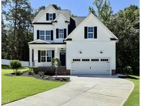 Charming two-story home with a black door, black shutters and a well-manicured lawn at 2628 Silver Gate Ct, Wake Forest, NC 27587