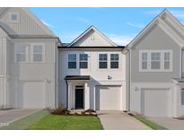 Charming new construction home with attached garage, white siding, and well manicured lawn at 545 Eversden Dr, Zebulon, NC 27597