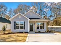 Gray exterior boasts a charming front porch and well-manicured lawn at 621 Ray St, Selma, NC 27576