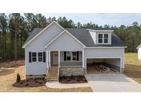 Charming single-Gathering home with gray siding, a stone foundation, and an attached two-car garage at 95 Purslane Dr, Franklinton, NC 27525