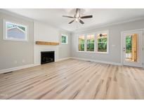 Bright living room features a cozy fireplace with wooden mantle and large windows at 95 Purslane Dr, Franklinton, NC 27525
