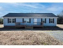 Ranch style home with gray siding, brown deck, and landscaping at 3720 Mt Zion Church Rd, Mebane, NC 27302
