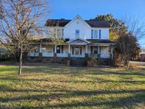 Two-story home with wrap-around porch and large yard at 523 E Main St, Haw River, NC 27258
