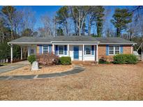 Brick ranch home with a covered porch, landscaped yard, and a spacious driveway at 5317 Ten Ten Rd, Apex, NC 27539