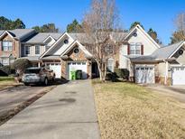 Charming townhome featuring a well-manicured lawn, attached garage, and inviting curb appeal in a desirable neighborhood at 9412 Harvest Acres Ct, Raleigh, NC 27617