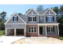 Charming two-story home with a two-car garage, brick accents, and a covered front porch at 1021 Smoke Willow Way # 130, Rolesville, NC 27571