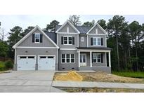 Charming two-story home with a two car garage, dark shutters, and covered front porch at 1021 Smoke Willow Way # 130, Rolesville, NC 27571