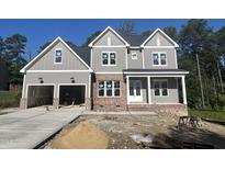 New construction two-story home featuring a brick base, neutral siding, three gables, and an attached two-car garage at 1021 Smoke Willow Way # 130, Rolesville, NC 27571