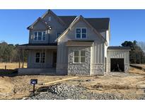 Two-story home featuring gray siding, stone accents, and an attached two car garage at 190 Broadleaf Ln, Louisburg, NC 27549