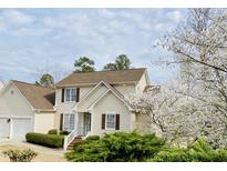 Charming two-story home with manicured landscaping and flowering tree at 306 Neuse Ridge Dr, Clayton, NC 27527