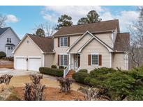 Charming traditional home with tan siding, brown shutters, manicured landscaping, and a two-car garage at 306 Neuse Ridge Dr, Clayton, NC 27527