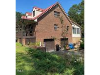 Brick home with attached two-car garage, red roof, and spacious porch at 515 Docs Rd, Lillington, NC 27546