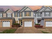 Three-story townhouses with stone accents and two-car garages at 5536 Nur Ln, Raleigh, NC 27606