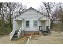 Front view of a white duplex with stairs and small yards at 645 Arch St, Henderson, NC 27536
