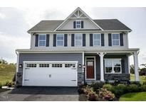 Two-story house with gray siding, white garage door, and landscaping at 1020 Country Pasture Cv, Wendell, NC 27591