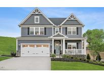 Charming two-story home featuring a well-manicured lawn, covered porch and a two-car garage with an ample driveway at 1024 Country Pasture Cv, Wendell, NC 27591