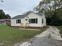 Updated home features a charming exterior with a new paint job and landscaping at 106 Joy St, Dunn, NC 28334