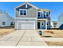 Two-story house with gray and blue siding, white garage door, and landscaping at 1070 Parkside Drive, Nashville, NC 27856