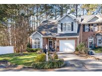 Brick front townhouse with driveway, landscaping, and white picket fence at 2112 White Pond Ct, Apex, NC 27523
