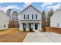 Two-story light blue house with black shutters and a concrete walkway at 2862 Filbert St, Raleigh, NC 27610