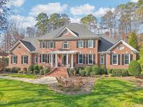 Brick two-story home with a large front yard and landscaping at 302 Champions Point Way, Cary, NC 27513