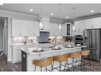 Modern kitchen with white cabinets, large island, and stainless steel appliances at 1051 Cross Rail Ln, Raleigh, NC 27603