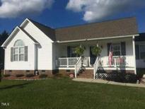 White single story house with gray roof, front porch and landscaping at 288 Rosa Cir, Willow Springs, NC 27592